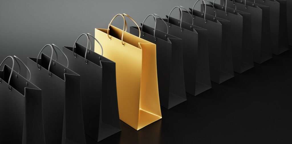 Golden shopping bag with black shopping bags