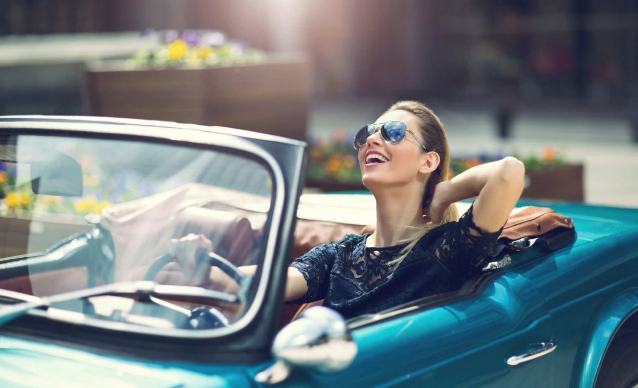 Portrait of beautiful sexy fashion woman model in sunglasses sitting in luxury retro cabriolet car